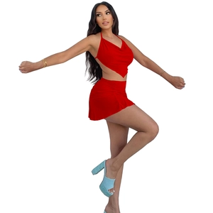 Detail of red two-piece set featuring halter neck crop top and ruched mini skirt