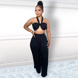 Détail d'un ensemble deux pièces noir avec haut dos nu croisé et pantalon large