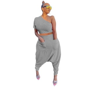 Detail of grey one-shoulder crop top and high-waisted harem pants with large pockets