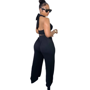 Détail d'un ensemble deux pièces noir avec haut dos nu et pantalon large à taille haute