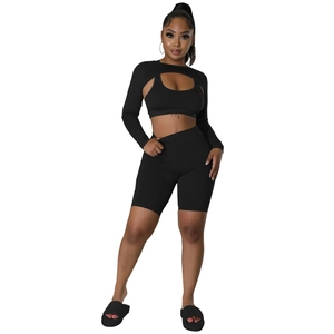 Three-piece black athletic set featuring long sleeve shrug, sports bra and biker shorts