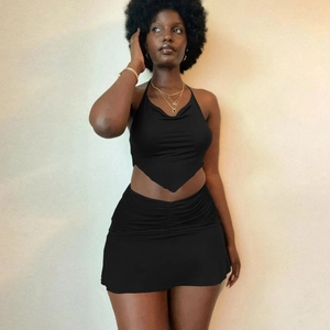 Detail of black halter backless crop top and ruched mini skirt set in high elastic fabric