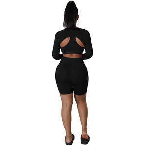 Rear view of black long-sleeve crop top with cutout design and high-waisted shorts