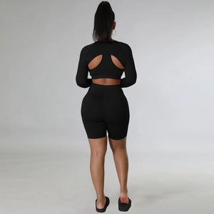 Back view of black three-piece sports set featuring a large circular cutout design
