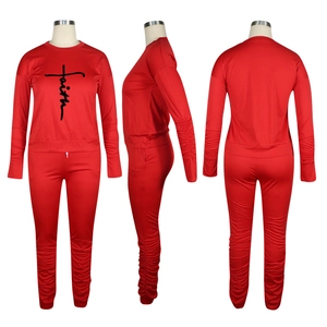 Detail of red two-piece tracksuit showing ruched sleeves and Faith print on the shirt