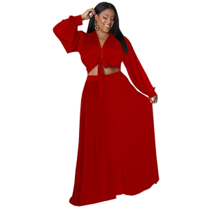 Dettaglio del top rosso a maniche lunghe con scollo a V e gonna lunga a vita alta