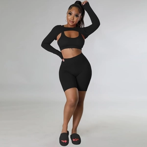 Close-up of black 3-piece sports set featuring long sleeve shrug, vest and high waist shorts