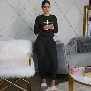 Close-up of black sweatshirt set with Faith print and jogger pants in a cozy home setting