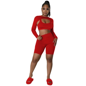 Three-piece red sports set featuring a hollow long sleeve top, sports bra, and cycling shorts