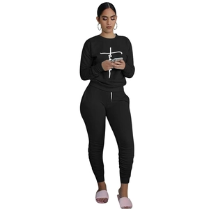 Detail of black long-sleeved tracksuit set with white Faith cross print and ruched legs