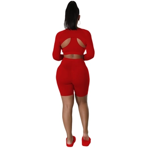 Close-up of red high-elastic sports set featuring long sleeve open back top and cycling shorts