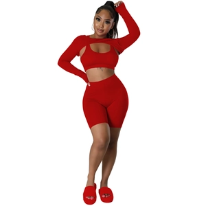 Front view of women's 3-piece red ribbed sports set including long sleeve top, vest and shorts