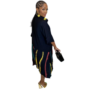Detail view of the black midi dress featuring abstract wave prints and large side pockets