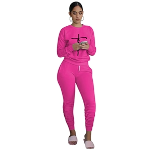 Detail of rose red tracksuit with faith lettering and ruched leg cuffs for women