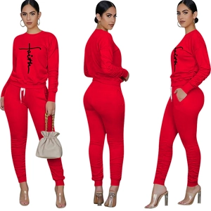 Detail view of red Faith print tracksuit featuring drawstring waist and ruched leg design