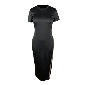 Détail d'une robe noire ajustée avec fente latérale ornée de strass et finition satinée