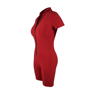 Close-up of red honeycomb textured fabric with black zipper on short sleeve jumpsuit