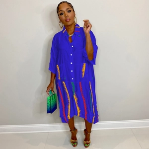Detail of blue shirt dress featuring colorful stripe patterns and large front pockets