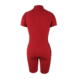 Macro detail of the deep red honeycomb textured fabric on this bodycon athletic romper