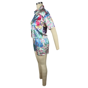 Detail view of floral satin two-piece shirt and shorts set with vibrant colorful prints