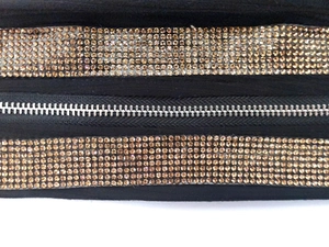 Détail de la fermeture éclair métallique avec rangées de strass ambrés étincelants