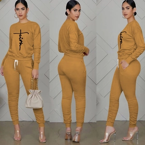 Detail view of mustard yellow Faith print tracksuit with cuffed sleeves and drawstring waist