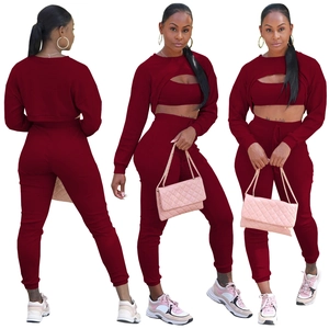 Completo tre pezzi in maglia a coste con crop top, gilet e pantaloni in colore rosso cupo