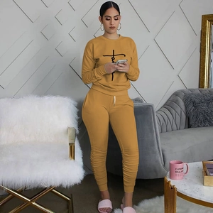 Detail of mustard yellow two-piece set featuring ruched legs and Faith cross print