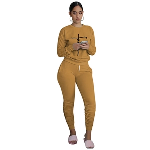 Detail of mustard yellow tracksuit set featuring Faith print and ruched leg hems