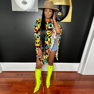 Detail of colorful faux fur printed shawl with vibrant neon yellow over-the-knee boots
