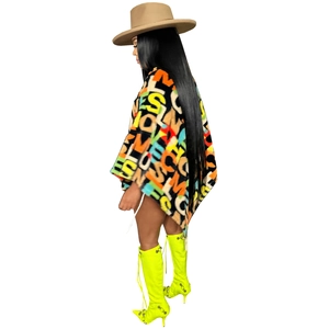 Detailed view of women's velvet poncho featuring vibrant colorful letter prints