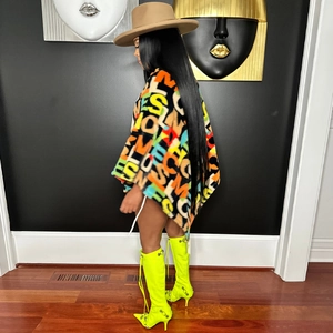 Detail of oversized velvet cape top with colorful letter prints and neon yellow boots