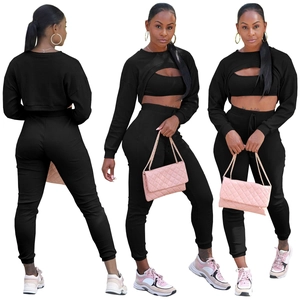 Tre viste del set nero in maglia a costine con top corto, gilet e pantaloni jogger