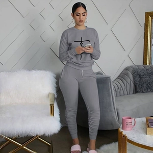 Detail of grey sports set featuring ruched jogging pants and graphic sweatshirt