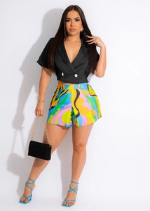 Close-up of a black double-breasted V-neck blazer top with colorful abstract print shorts