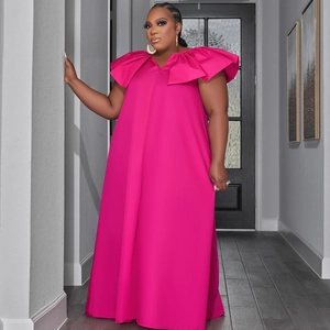 Detail of fuchsia maxi dress featuring exaggerated ruffle shoulder and V-neckline design