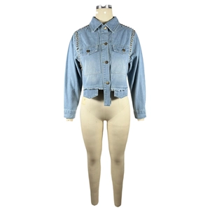 Détails d'une veste en jean bleu clair avec clous argentés et ourlet brut sur mannequin
