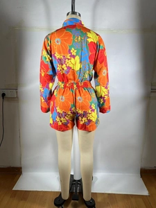 Back view of a vibrant floral print two-piece set featuring long sleeve shirt and shorts