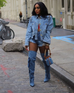 Détail de la veste en jean bleu clair avec épaules cloutées et boutons dorés