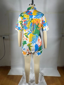 Detail of tropical floral print shirt and shorts with beige wavy lace trim on edges