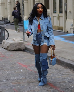 Gros plan sur veste en jean bleu clair avec bords effilochés et boutons métalliques