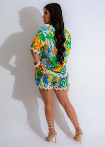 Detail of scalloped wavy edges on vibrant tropical print shirt and shorts co-ord set