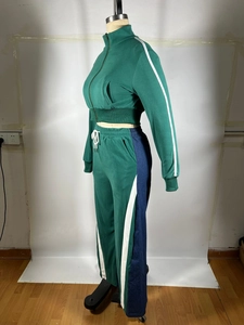 Detail of dark green tracksuit featuring white stripes and contrasting navy side panels