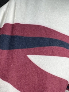 Detail of soft fleece fabric featuring bold dark red and navy blue striped patterns