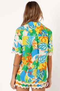 Detail view of tropical print set with scalloped edges on sleeve and shorts hem