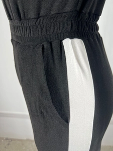 Close-up of elastic waistband and side white stripe on black suede denim jumpsuit
