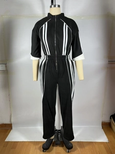 Détail d'une combinaison rétro avec col zippé et bandes blanches contrastées sur fond noir