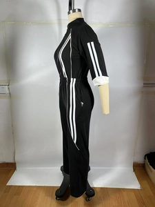Détail d'une combinaison de sport noire avec doubles rayures blanches latérales et zip taille