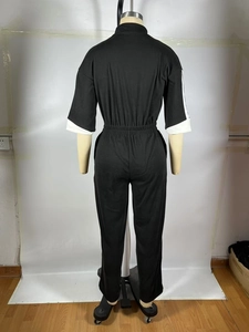 Détail de la taille élastique plissée sur une combinaison noire à poignets blancs