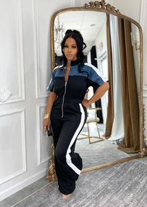 Detail of slim-fit jumpsuit featuring color-block design and silver metal front zipper